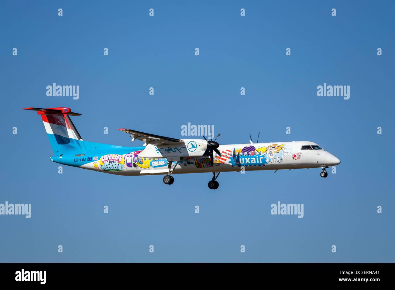 Monaco, Germania - Febbraio 28. 2021 : Luxair Bombardier DHC-8-400 con registrazione aereo LX-LQA in avvicinamento alla pista meridionale 08R di Foto Stock