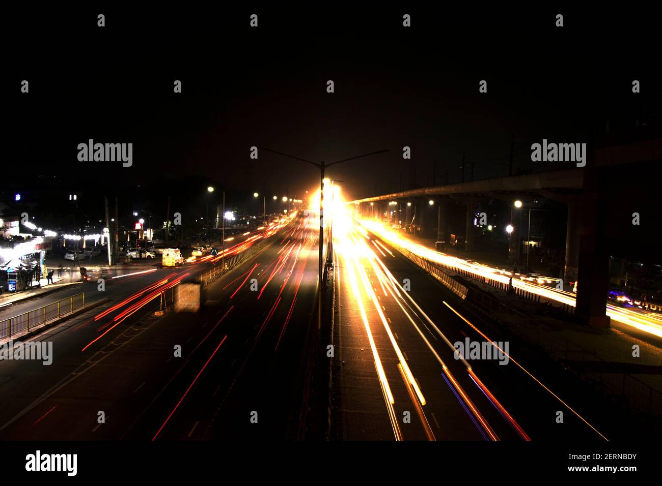 Velocità Traffic tracce di luce su autostrada, lunga esposizione, sfondo urbano e cielo scuro Foto Stock