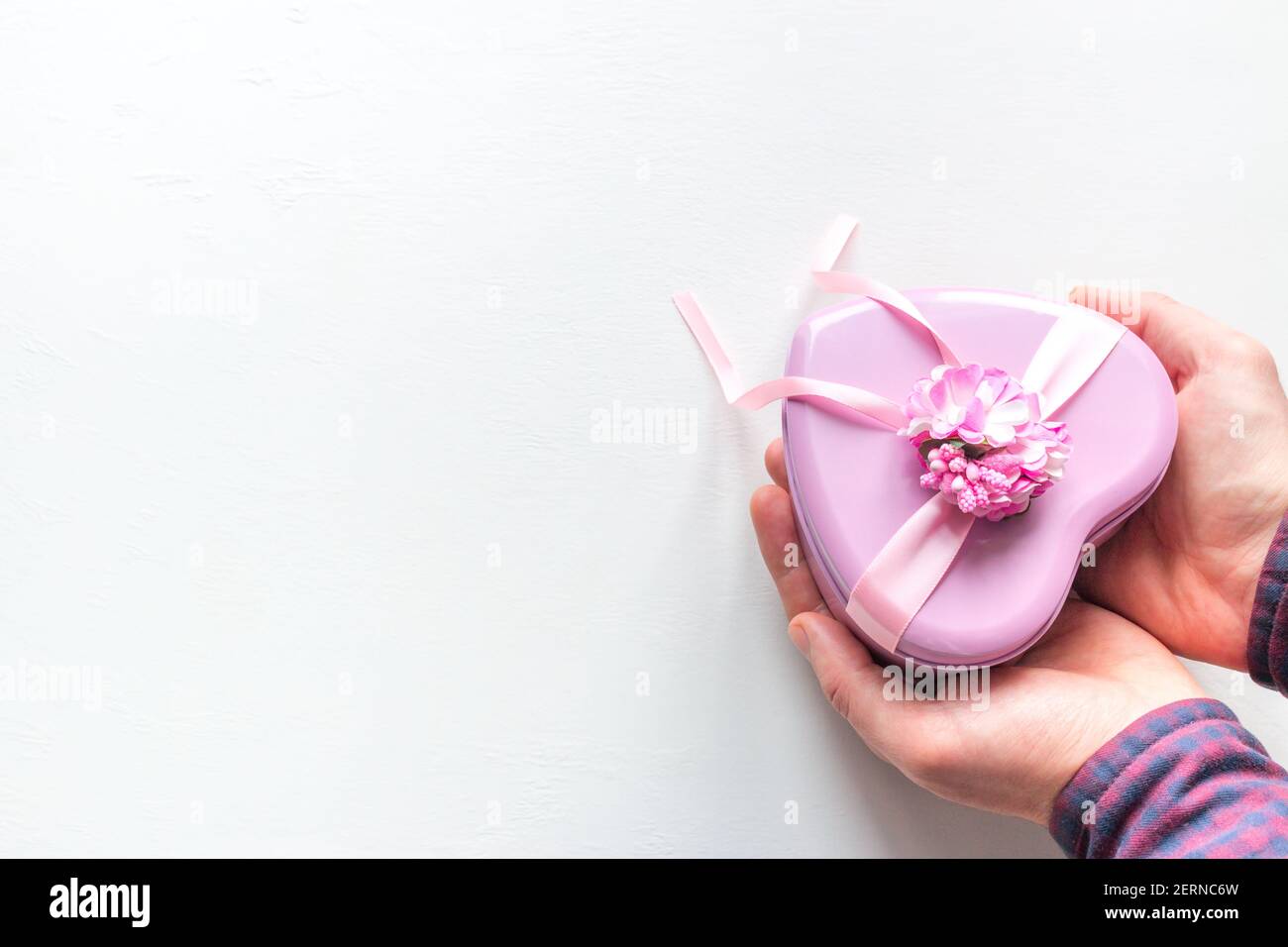 l'uomo dà un dono a forma di cuore Per San Valentino su sfondo bianco con spazio per testo Foto Stock