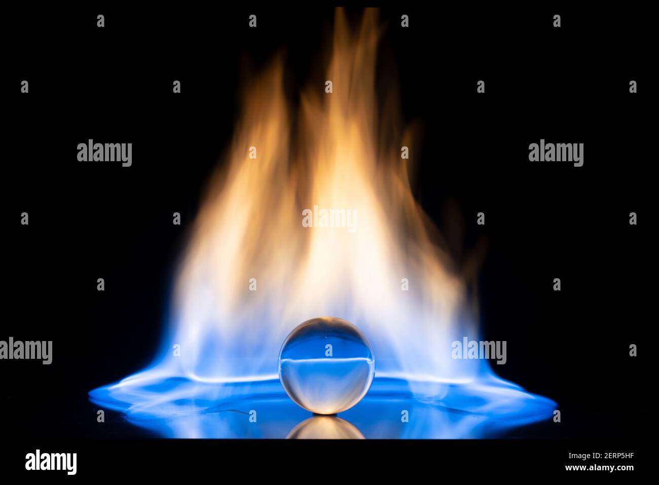 Palla di vetro con fiamme fuoco su sfondo nero. Spazio di copia. Foto Stock