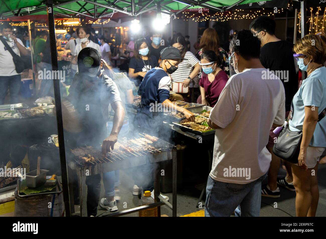Feb 14, 2021 Man grigliare barbecue al mercato Domenica a Makati città, Metro Manila, Filippine Foto Stock