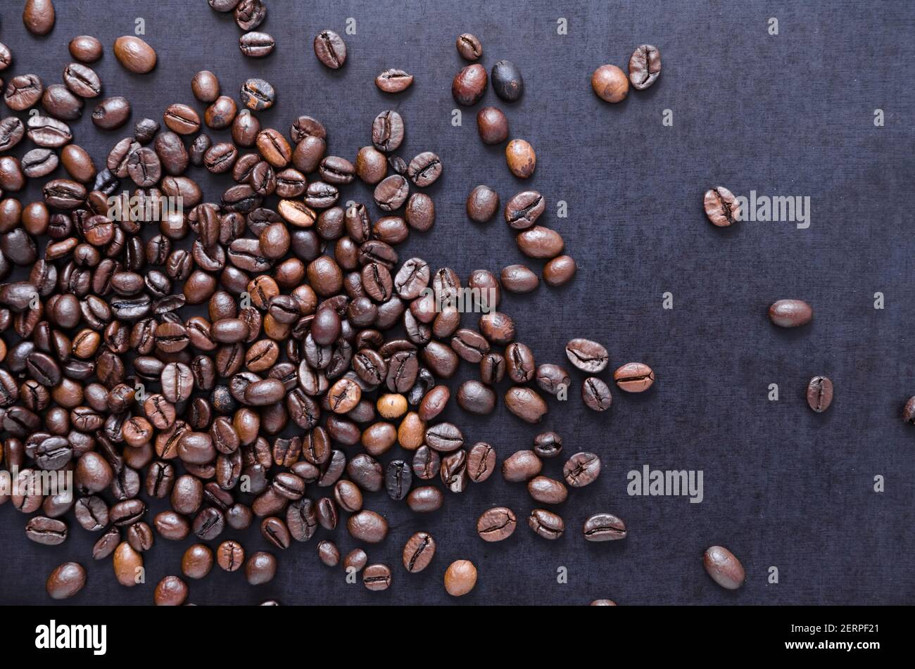 Chicchi di caffè espresso torrefatti sfusi su sfondo scuro, primo piano, vista piatta dall'alto, vita morta, mi piace il concetto di caffè Foto Stock