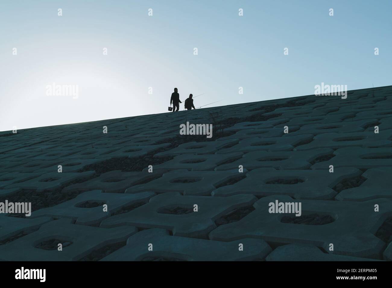 Due persone che detengono canna da pesca camminano su una parete di mare a Koizumi Beach (parete più alta in questa prefettura con 14, 7 metri) il 23 novembre 2020 nella zona della città di Kesennuma, a Miyagi, Giappone. Quasi 10 anni dopo il terremoto dell'M9 e lo tsunami devastante, Tohoku (Giappone del Nord Est) è protetto da un massiccio muro di mare. Dalla prefettura di Fukushima alla prefettura di Iwate, più di 300 km di barriera d'onda sono già finiti. Il muro è alto da 3 metri a 15 metri. 23 novembre 2020 Credit: Nicolas Datiche/AFLO/Alamy Live News Foto Stock