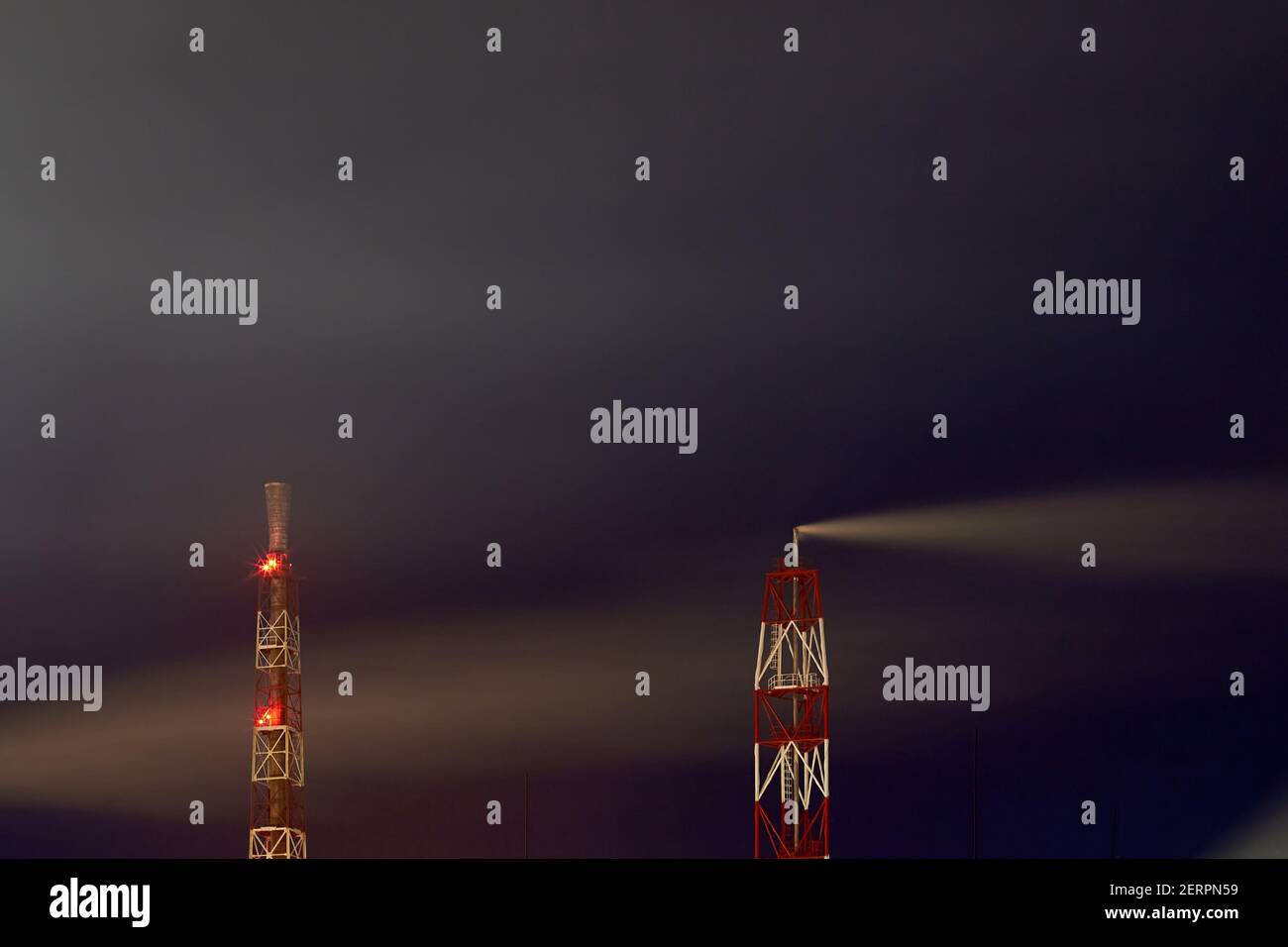 Segnalato con luci rosse tubi di fumo di impianto petrolchimico di notte scuro drammatico cielo lungo tempo di esposizione con copyspace. Concetto di ambiente Foto Stock