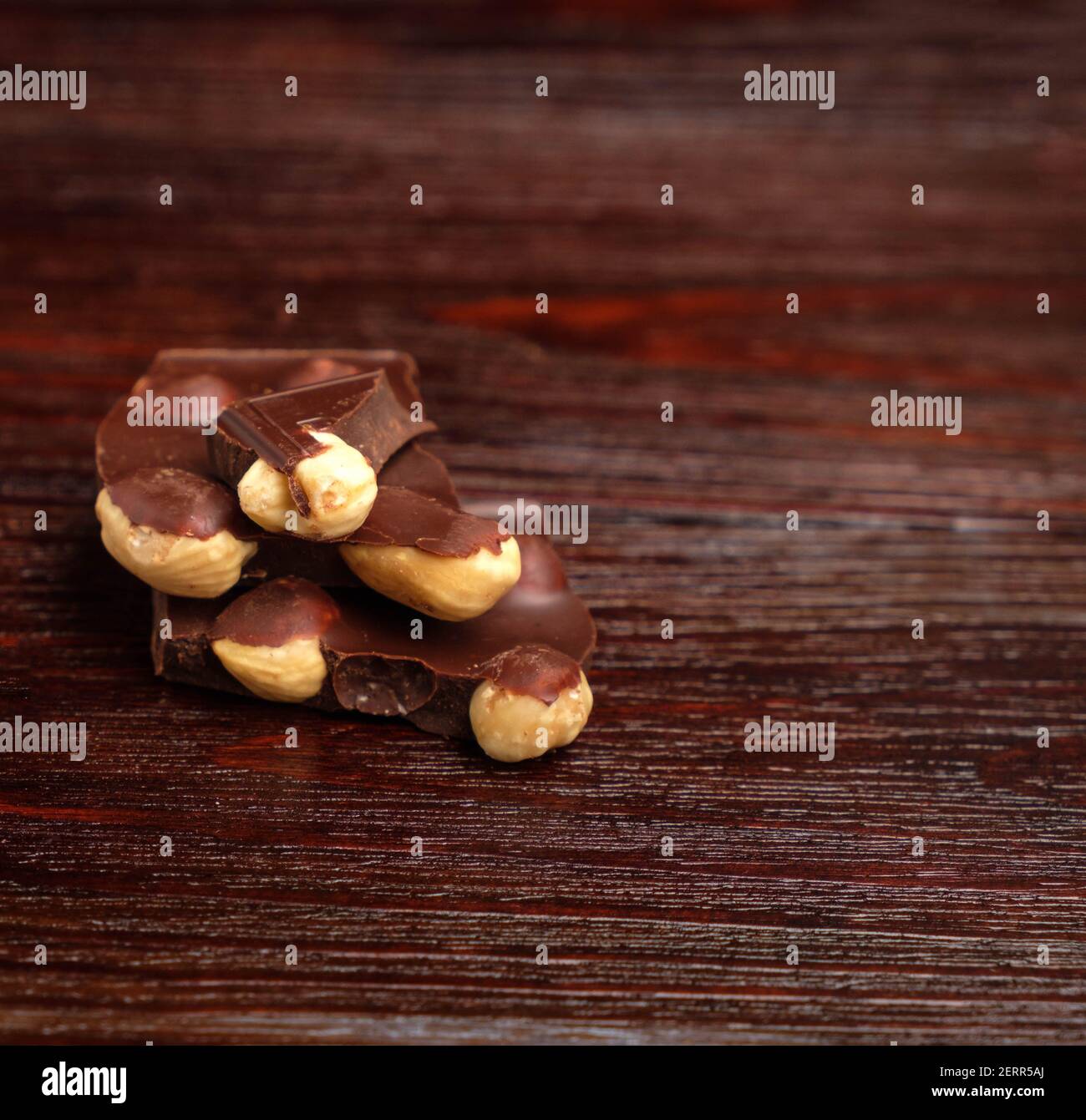 Pezzi di cioccolato e noci su sfondo scuro Foto Stock