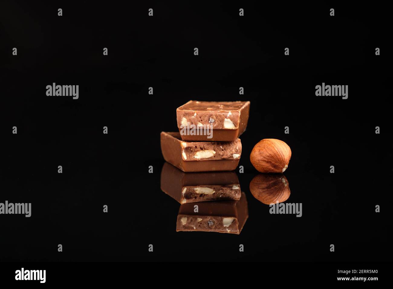 Pezzi di cioccolato e noci su uno sfondo scuro isolato Foto Stock