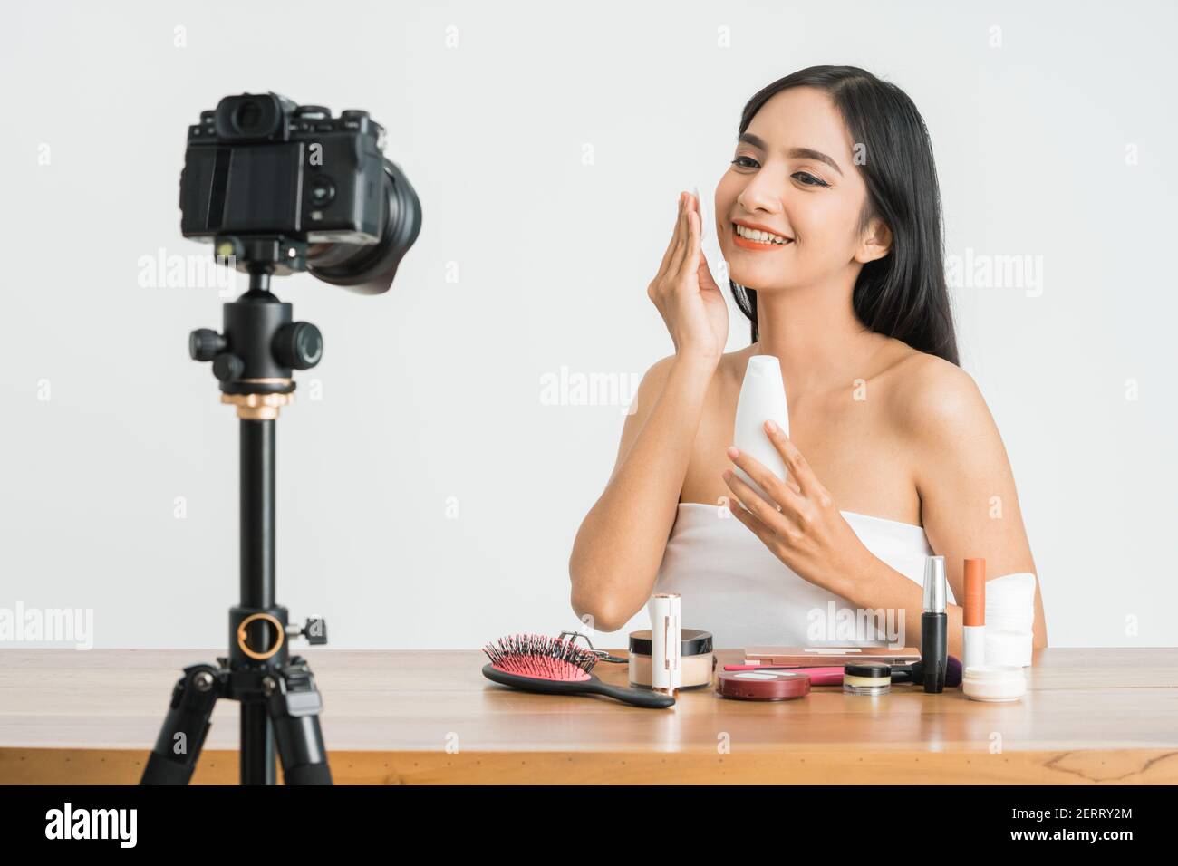 Giovane bella donna asiatica professionale di bellezza vlogger o blogger registrazione crea tutorial da condividere sui social media in bianco sfondo Foto Stock