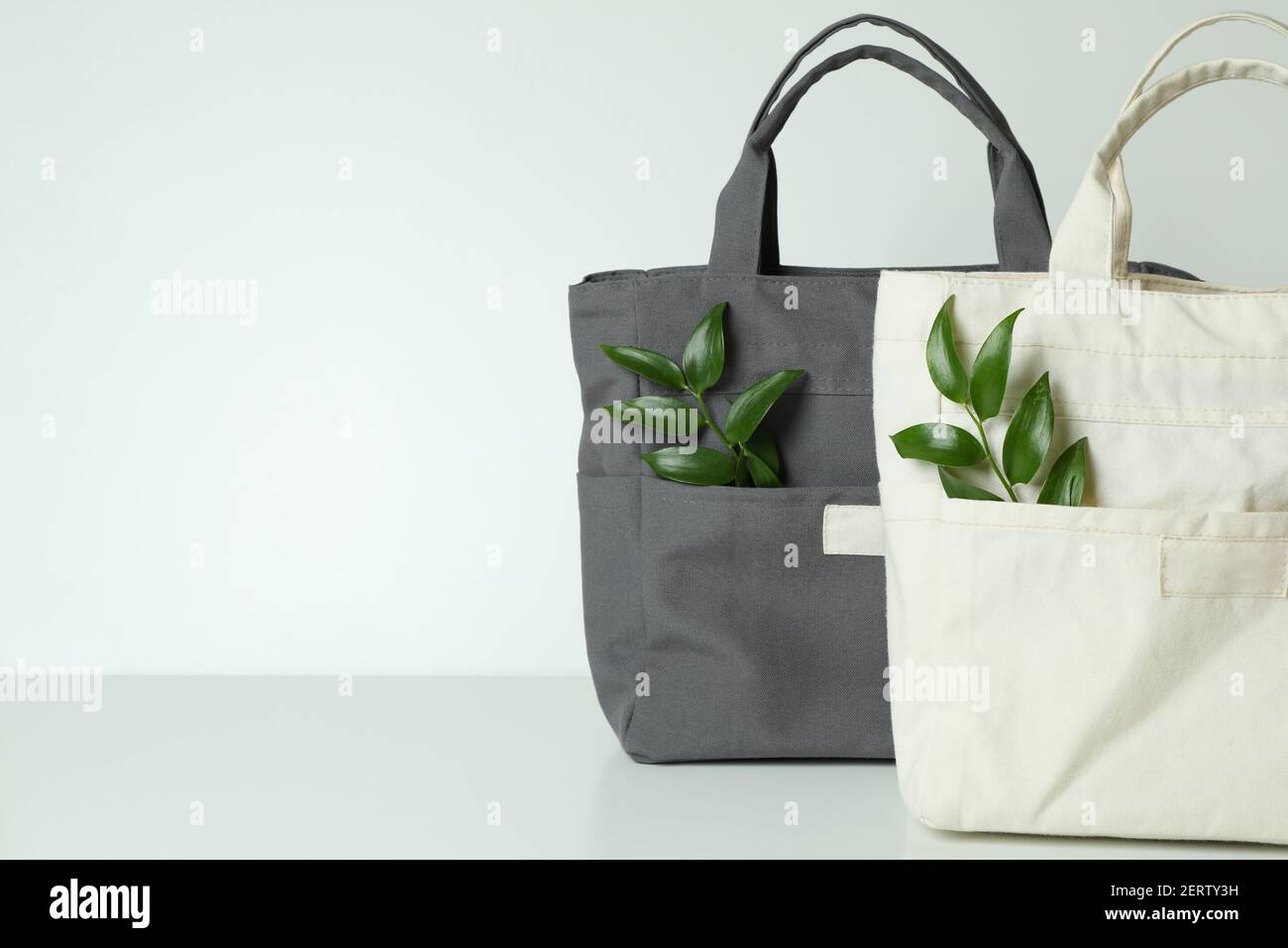 Eleganti borse ecologiche con rametti su sfondo bianco Foto stock - Alamy