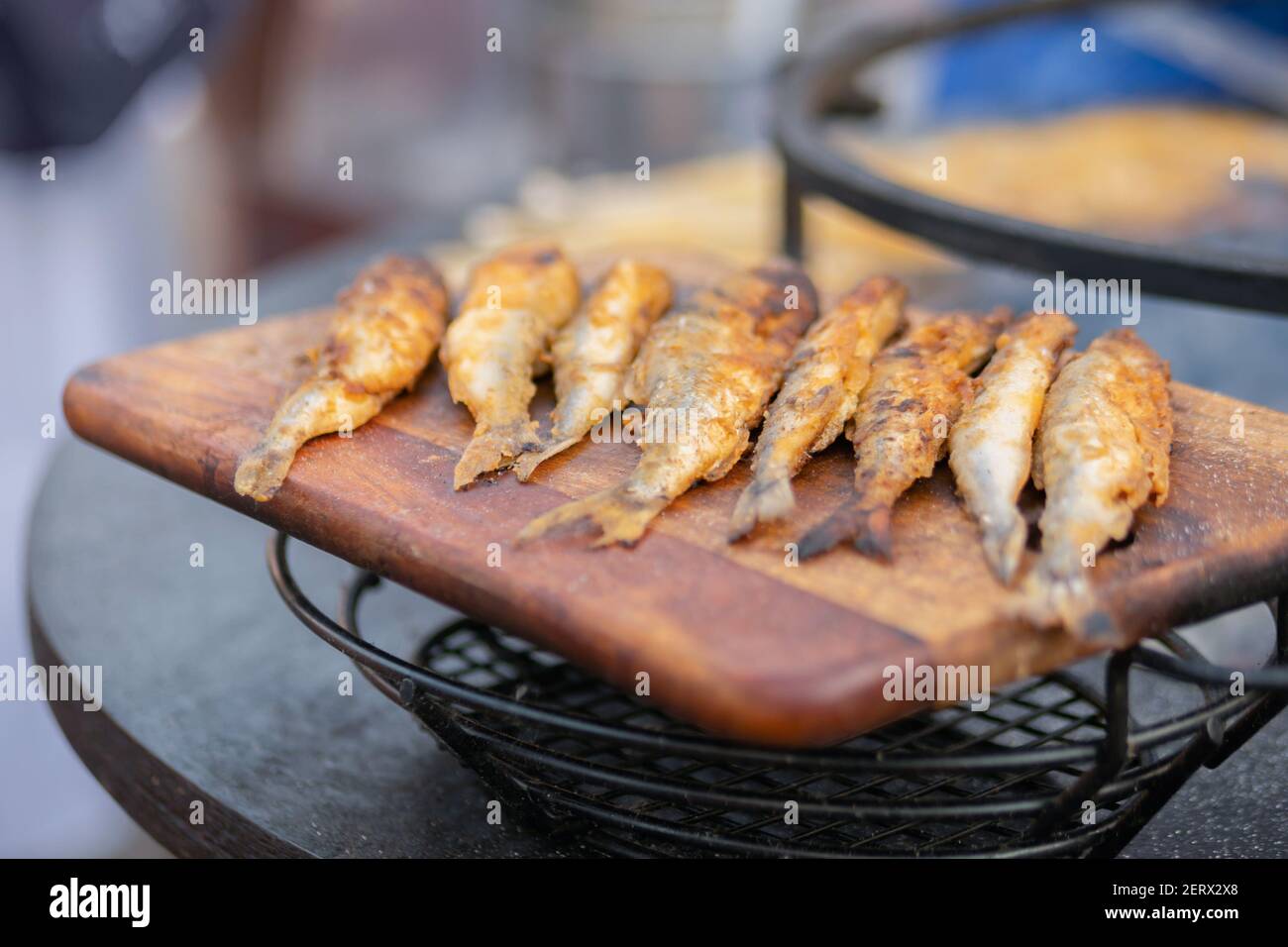 Pesce europeo puzzato croccante su tagliere di legno a. festival del cibo Foto Stock