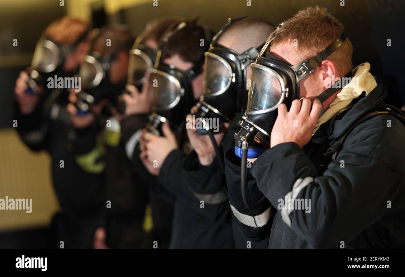 Tirocini che provano le maschere degli apparecchi respiratori Foto Stock