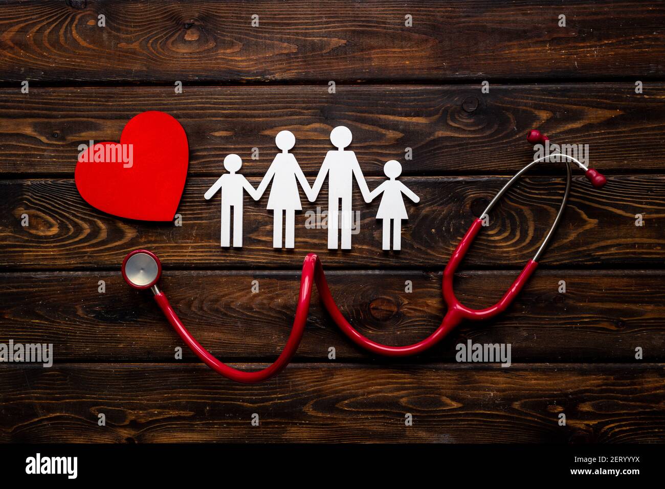 Piatto con cuore, stetoscopio e figura di famiglia. Concetto di assistenza medica Foto Stock