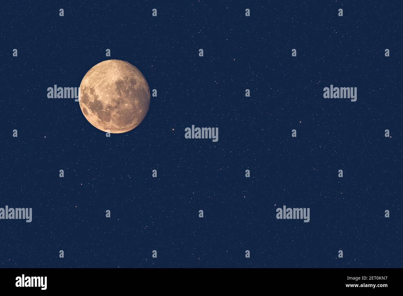 Luna piena al crepuscolo che risplende contro il cielo stellato blu scuro sfondo Foto Stock