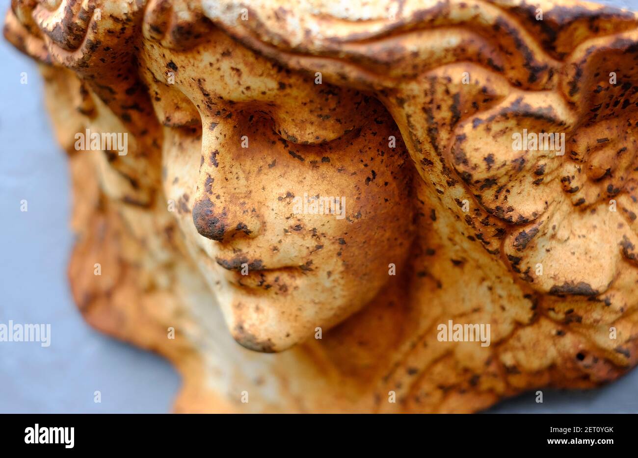 faccia angelica femminile su giardino in metallo arrugginito Foto Stock