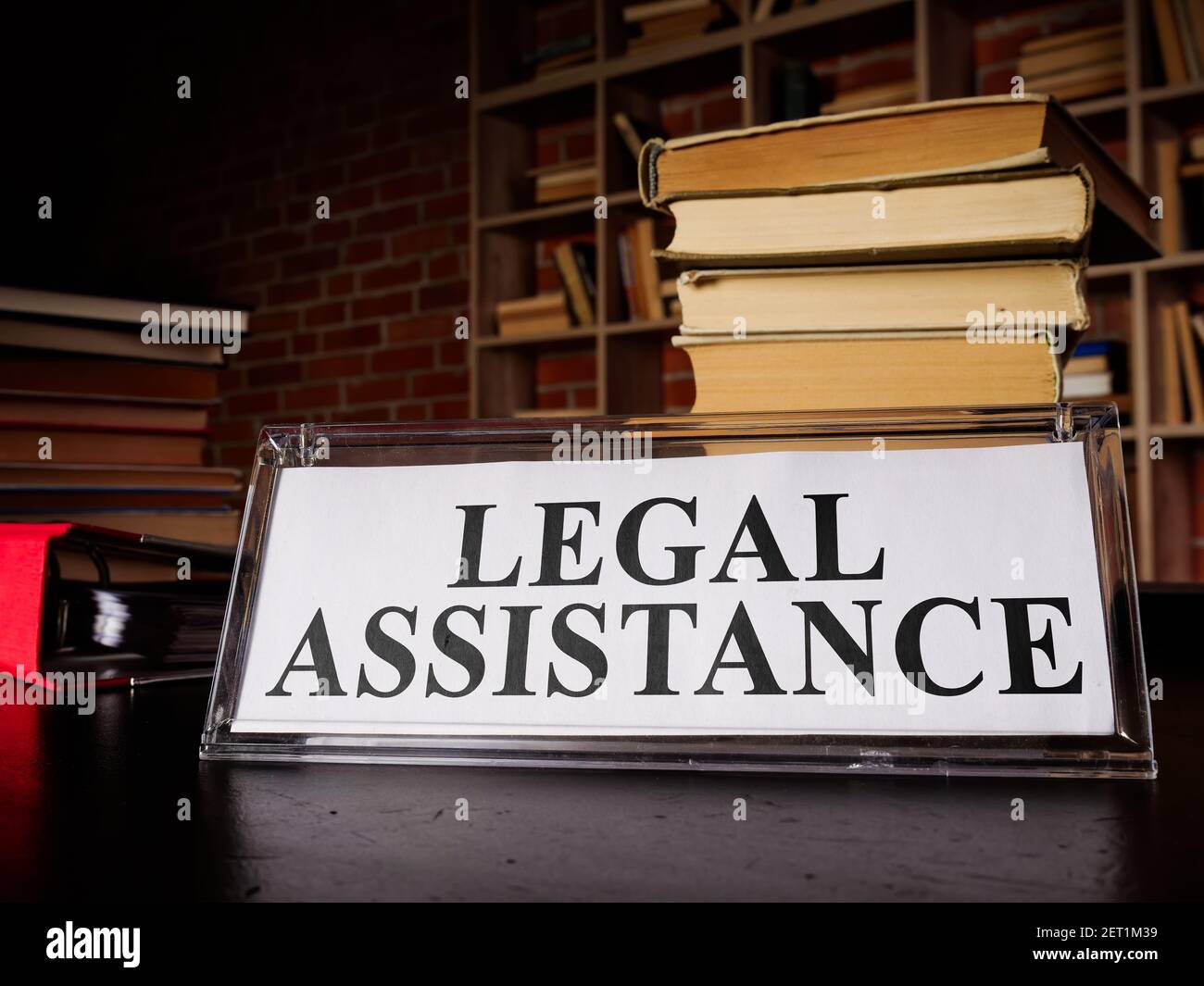 Targa di assistenza legale e pila di leggi e documenti. Foto Stock