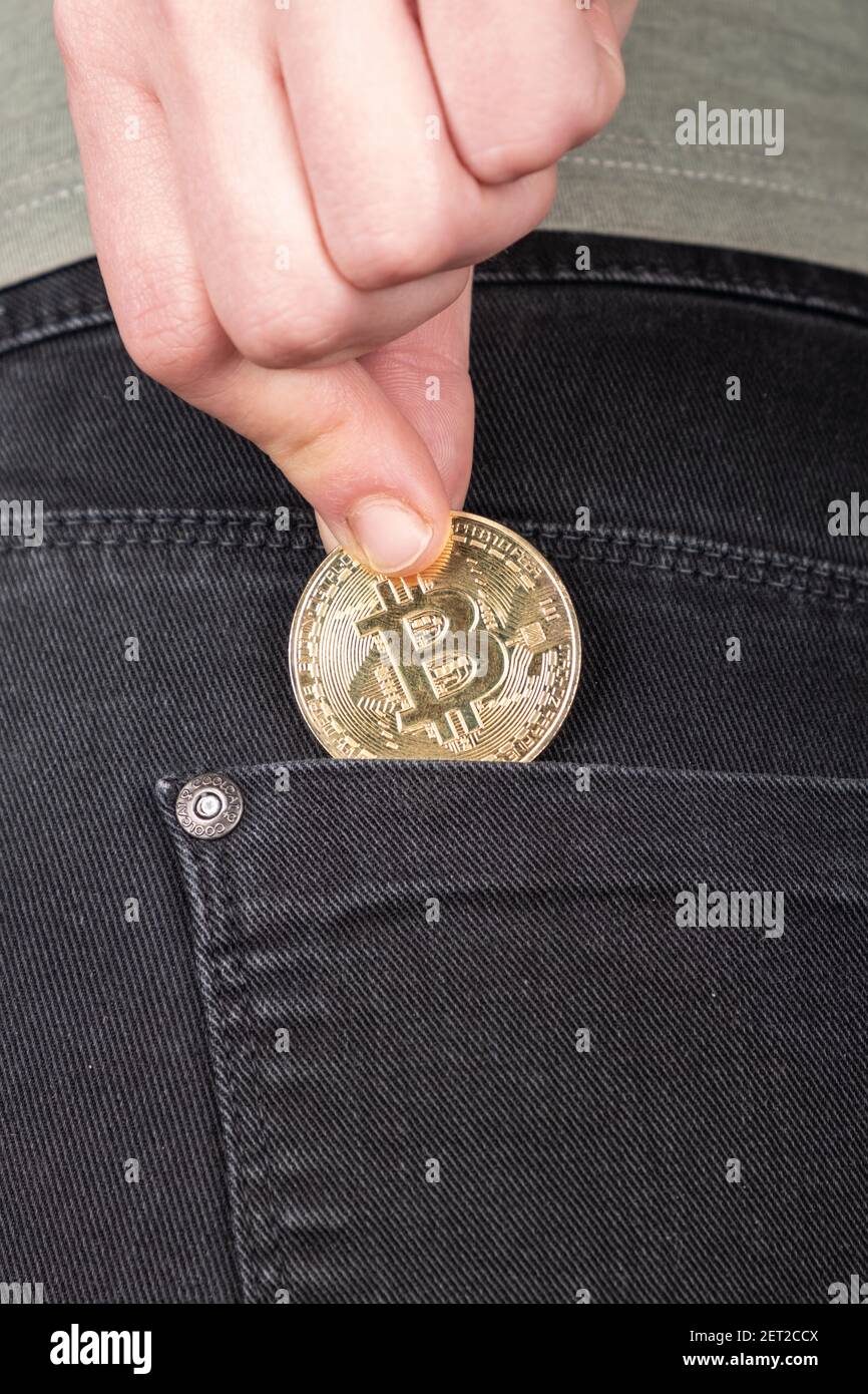 accumulo di bitcoin, investimento in criptovaluta btc, moneta d'oro in tasca Foto Stock