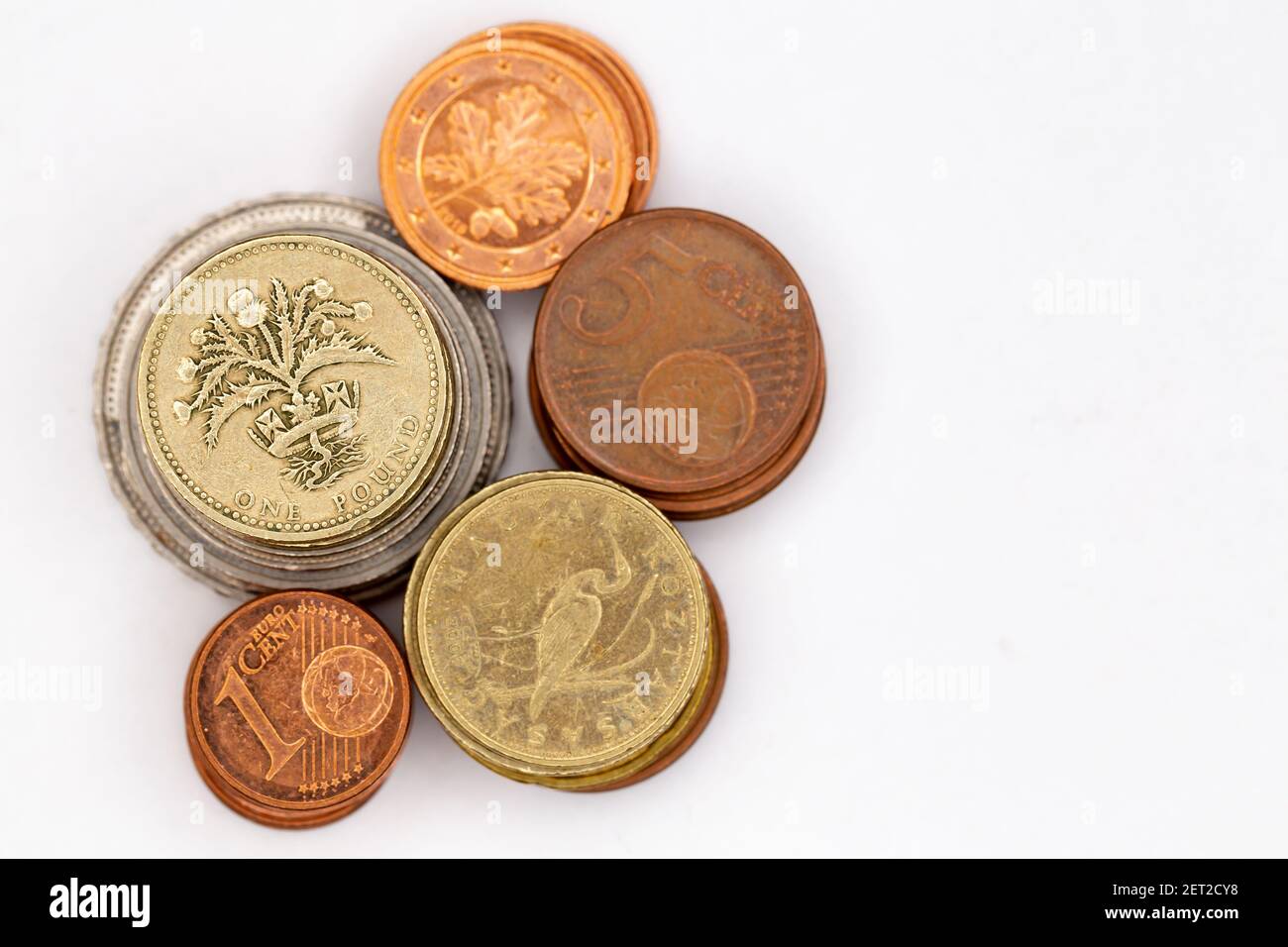 Pile di monete di paesi diversi. Oggetto illuminato con luce artificiale dall'alto. Foto Stock