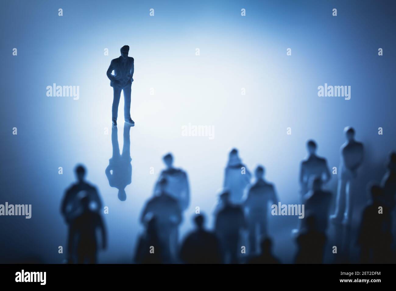 Uomo singolo in piedi davanti a un gruppo di persone. Leader, influencer, guida. Figurine. Foto Stock