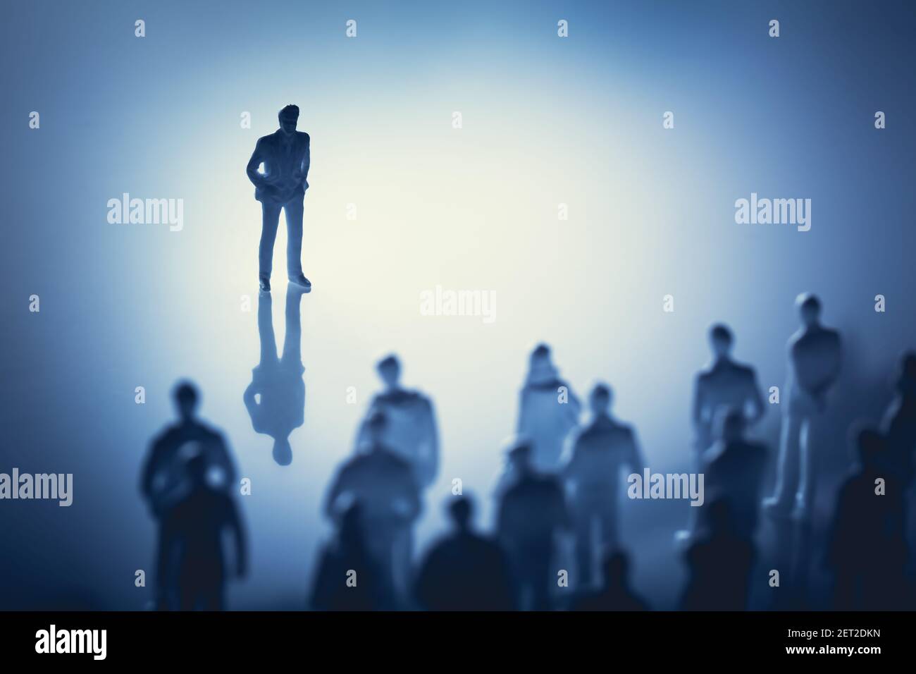 Uomo singolo in piedi davanti a un gruppo di persone. Leader, influencer, guida. Figurine. Foto Stock