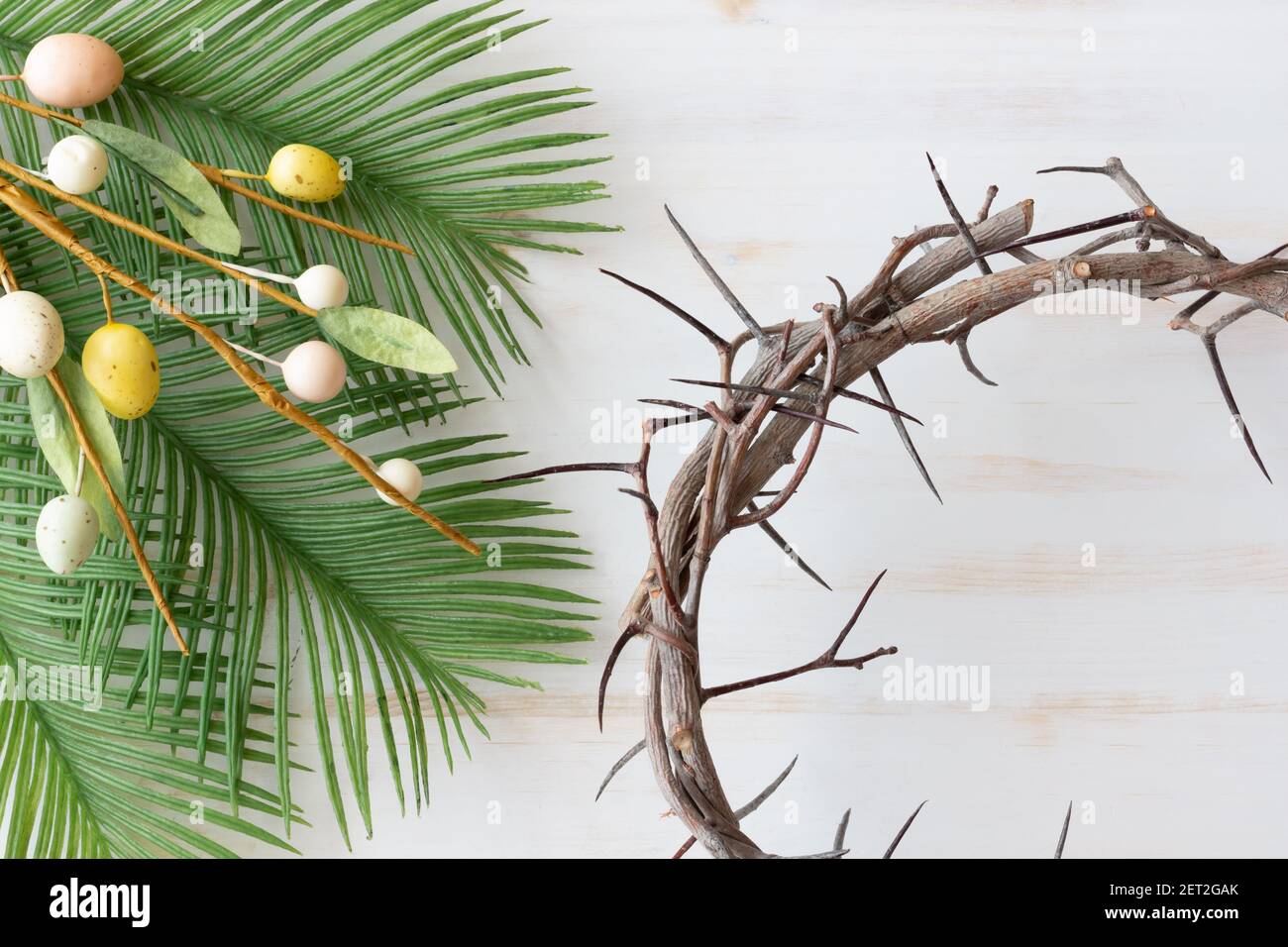 corona di spine con fronde di palma e ramo con decorativo uova di pasqua su  sfondo di legno bianco Foto stock - Alamy