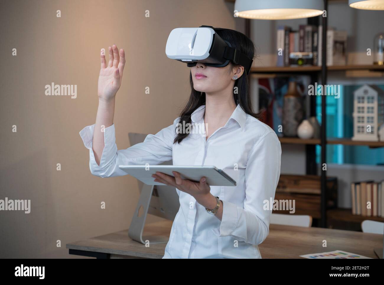 Donna che indossa occhiali VR a casa. Foto Stock