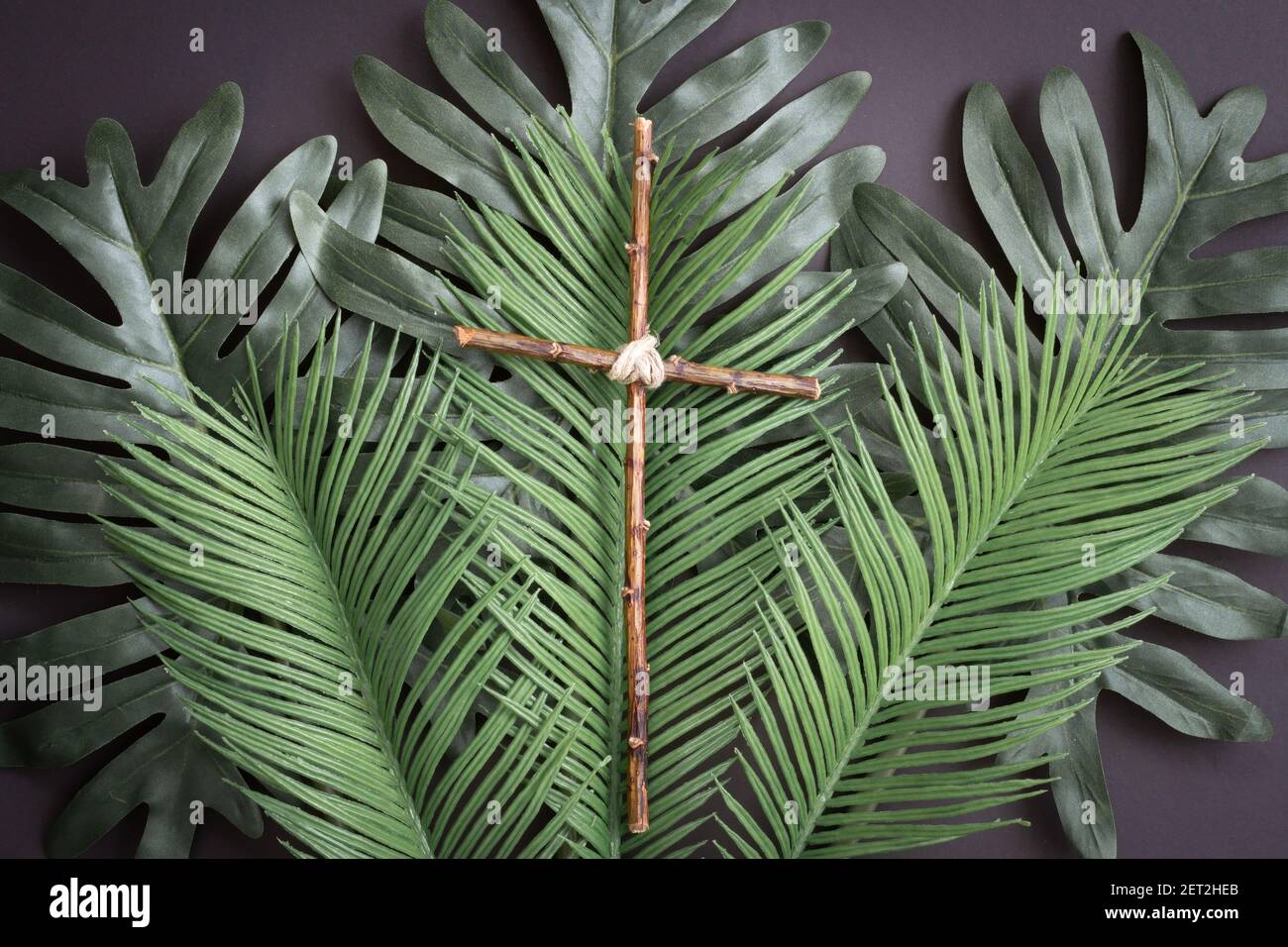 croce di legno su foglie di palma Foto Stock