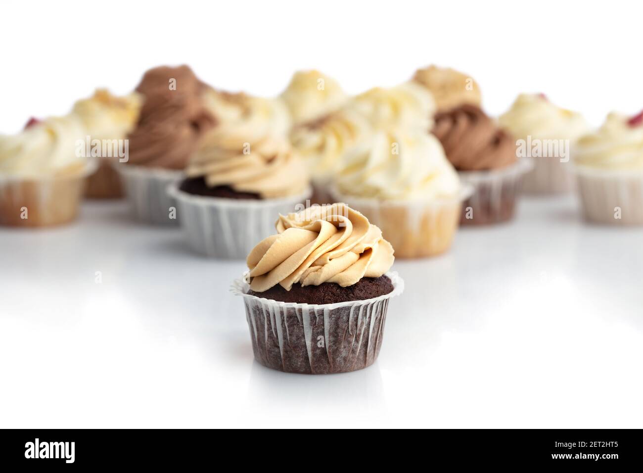 Cupcake al caramello ghiacciato da vicino. Muffin sfocati sullo sfondo. Dolcezza. Dessert. Foto Stock