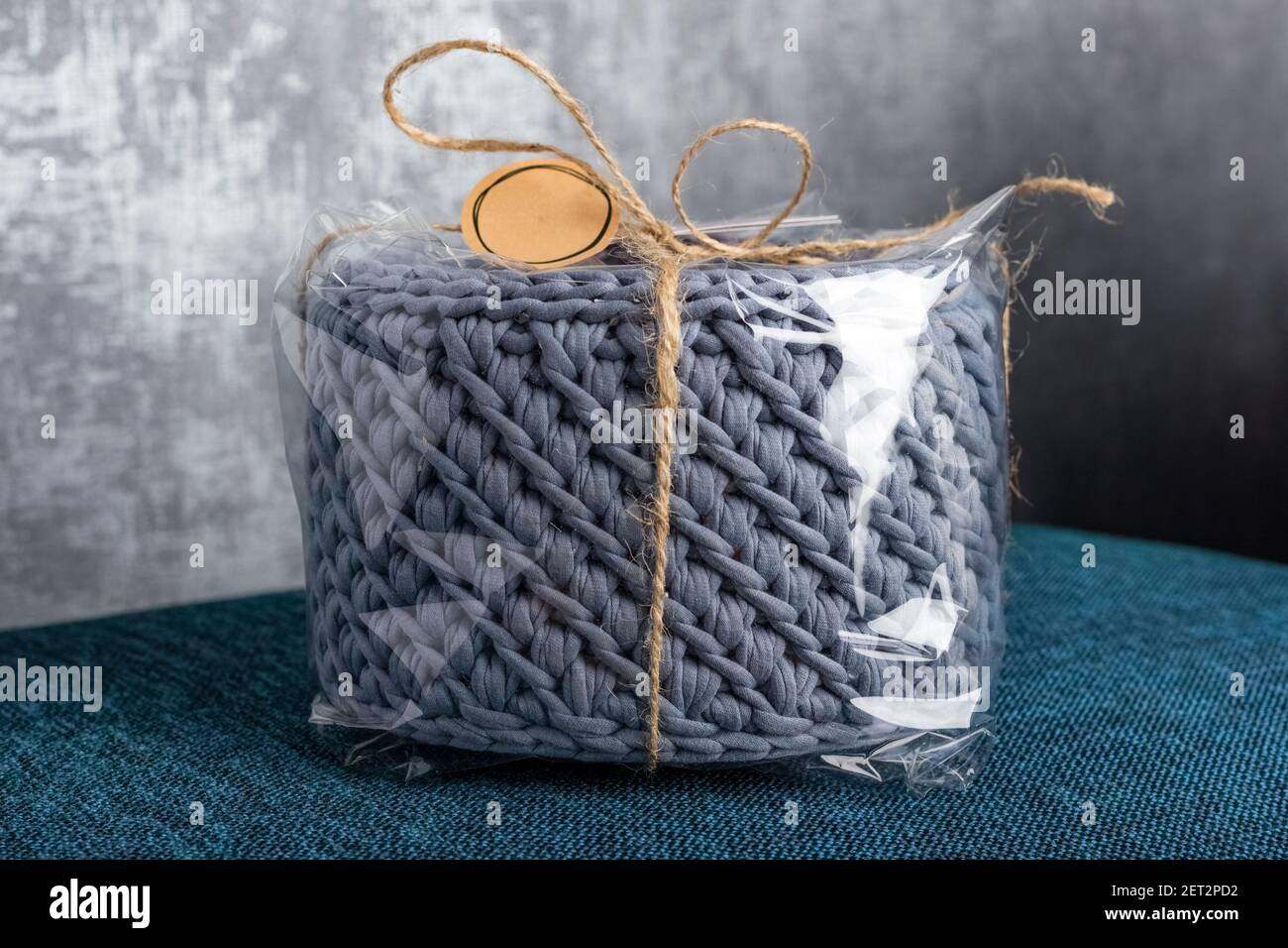 confezione regalo con cesto grigio fatto a mano. trama di trecce in tessuto lavorato a maglia Foto Stock