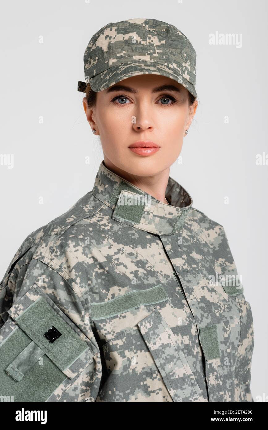 Ritratto di una donna militare che guarda la fotocamera isolata in grigio Foto Stock