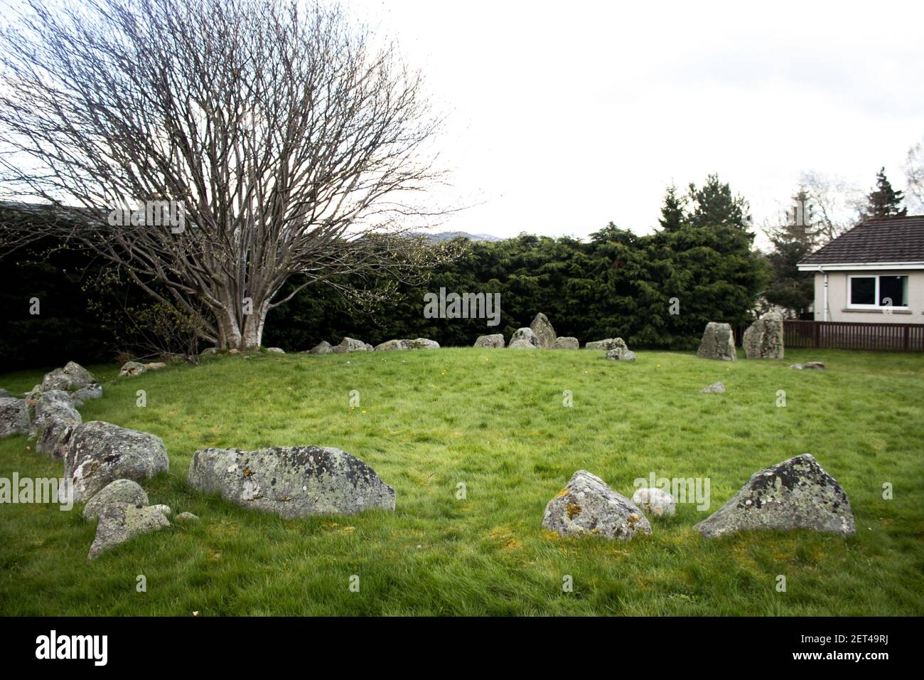 Un antico cerchio di pietra, ancora in parte sepolto, nei sobborghi della città scozzese di Aviemore Foto Stock