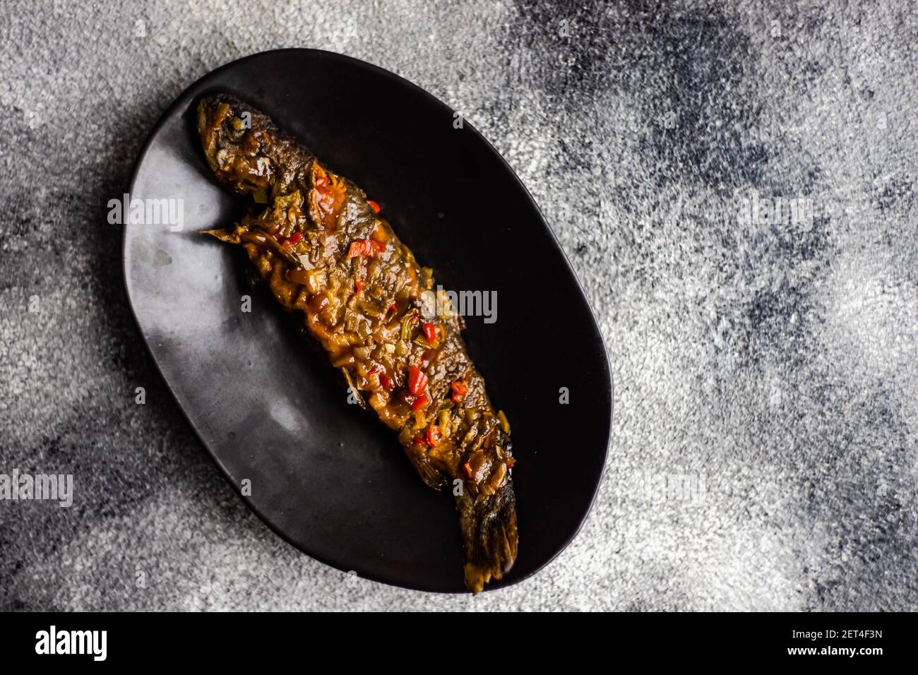 Vista dall'alto di un'intera trota arrosto in dolce asiatico e salsa affosata Foto Stock