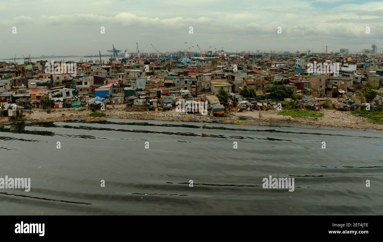 Zona delle baraccopoli vicino al porto di Manila, Phillippines, vista dall'alto. Molta immondizia in acqua. Foto Stock