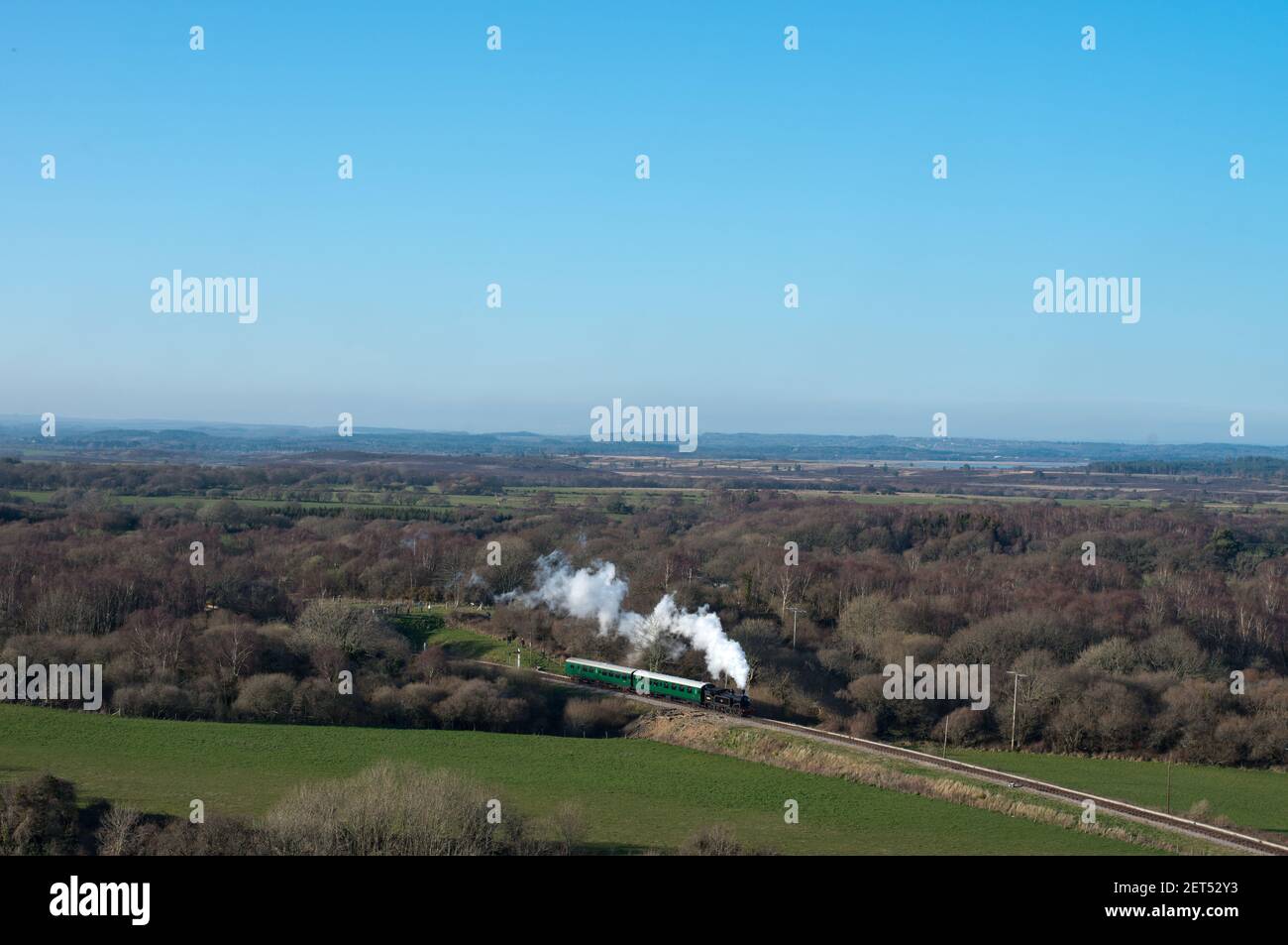 una locomotiva a vapore vintage tira un breve treno attraverso scenic Paesaggio sulla ferrovia Swanage Heritage nel Regno Unito Foto Stock