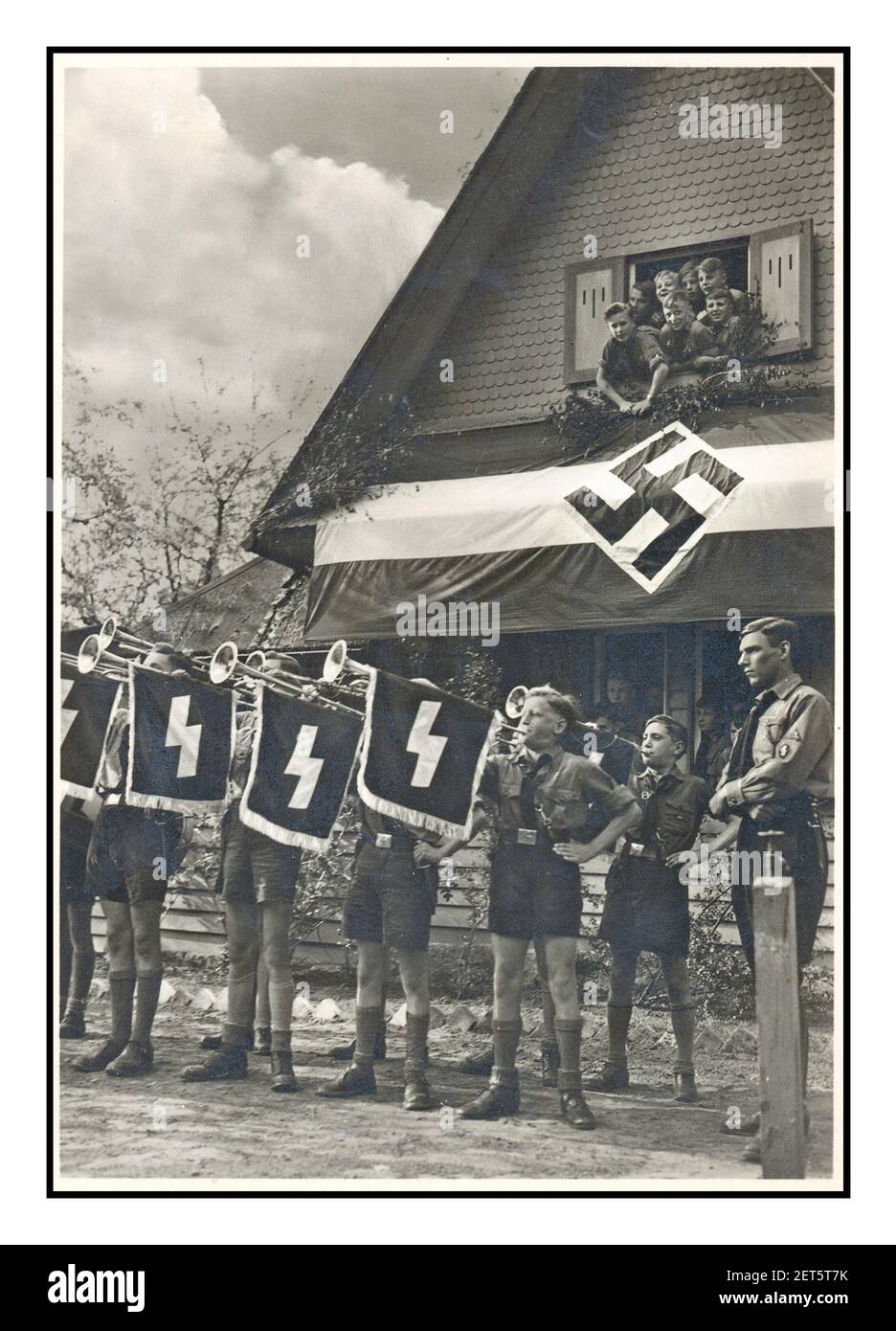 1930's Vintage Hitler Youth nazista Propaganda immagine dei ragazzi Hitler Jugend in un viaggio a tema nazista, soffiando un fanfare sulla sfilata che mostra swastika e simboli militari Germania 1934 Foto Stock