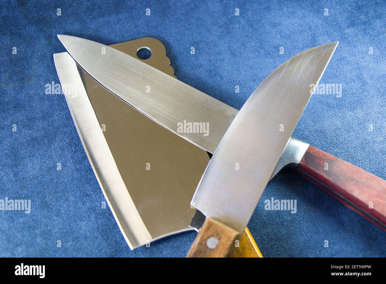Una collezione di coltelli da cucina su sfondo blu, utensili e strumenti per cucinare. Foto Stock