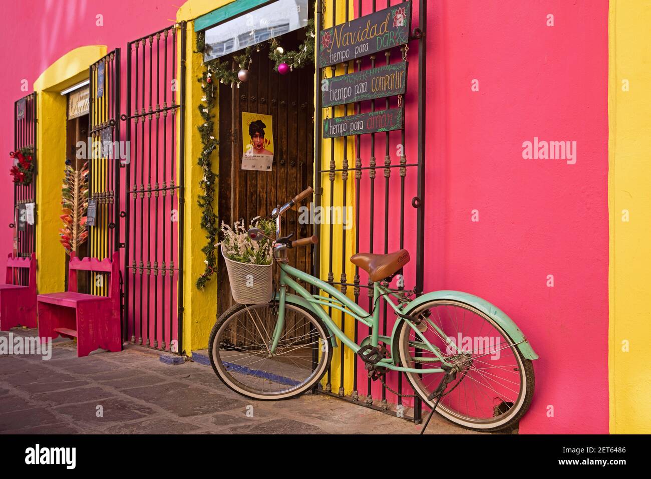 Colorato rosa e giallo storefront con bicicletta decorativa nella città Puebla, Messico Foto Stock