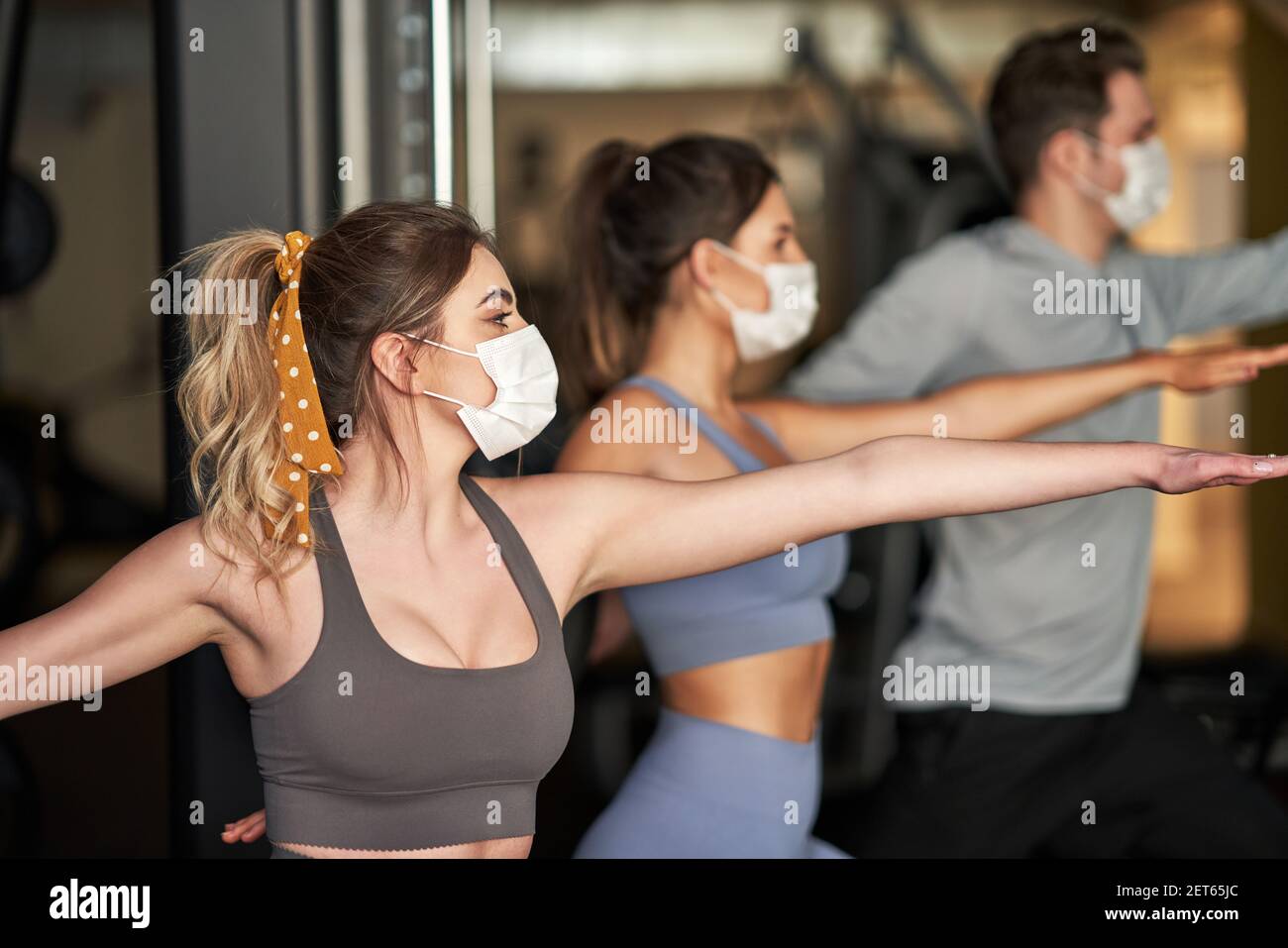 Gruppo di persone che indossano maschere che si allenano in palestra Foto Stock