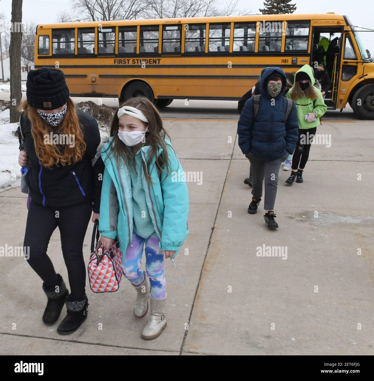 Racine, Wisconsin, Stati Uniti. 1 marzo 2021. Gli studenti arrivano alla Gilmore fine Arts School di Racine, Wisconsin, quando il Racine Unified School District, il quinto distretto scolastico più grande del Wisconsin, ritorna all'apprendimento di persona lunedì 1 marzo 2021. Le scuole sono chiuse di persona dal 13 marzo 2020. Circa il 53% dei 16,600 distretti tornerà per l'apprendimento di persona. Il distretto scolastico ha dovuto ottenere più autobus per essere in grado di bus studenti con protocolli di distanziamento sociale in atto. La decisione di riaprire è contraria agli insegnanti che vogliono essere vaccinati per primi e che sono sostenuti da persone che hanno desiderato Foto Stock