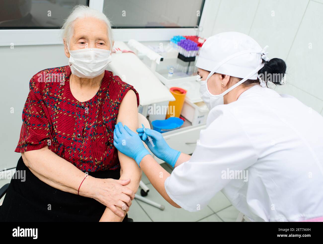il medico o l'infermiere inietta un farmaco o un vaccino nella spalla di una donna anziana. Foto Stock