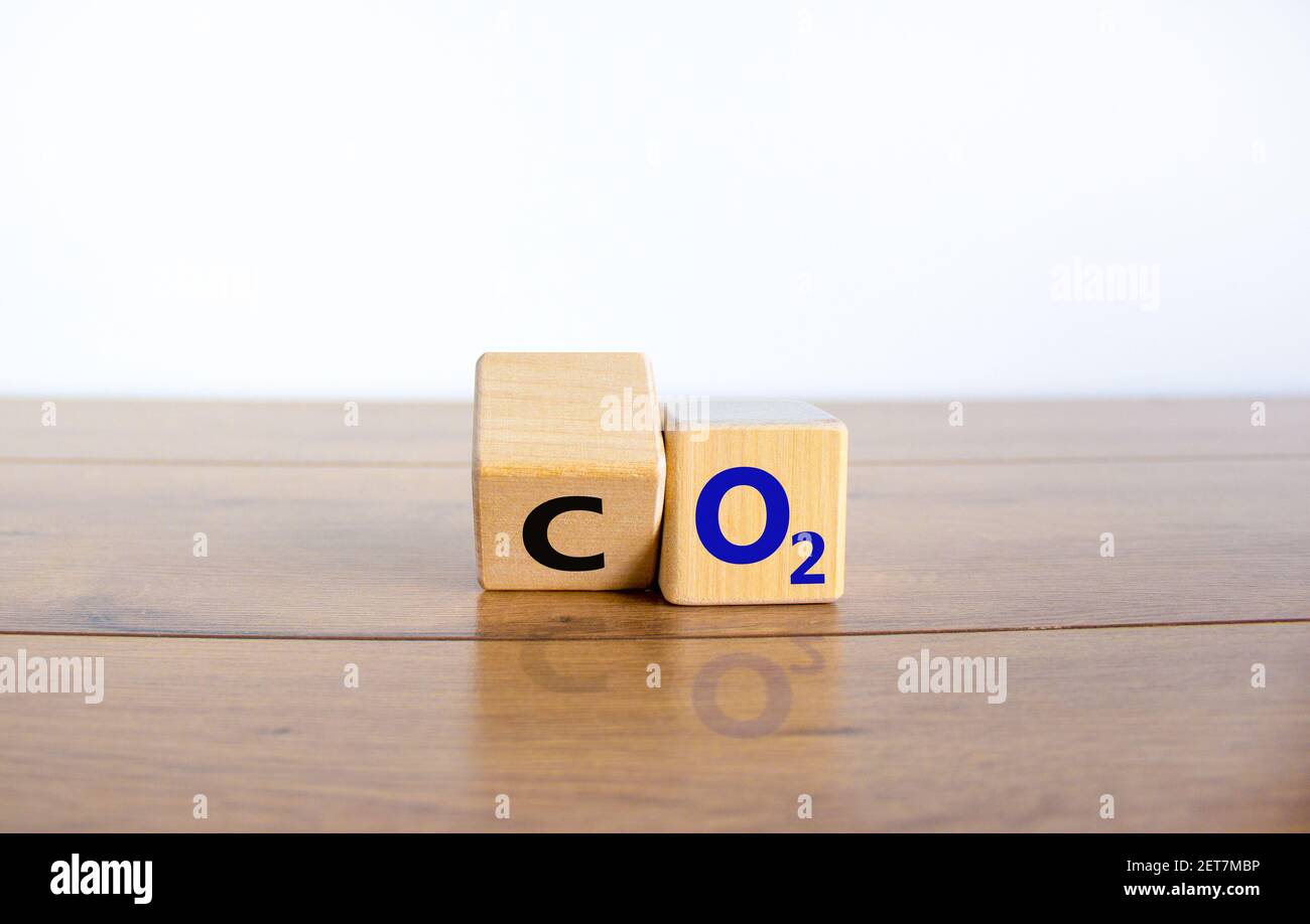 Simbolo CO2 o O2. Girò il cubo di legno e cambiò le parole 'CO2, anidride carbonica' in 'O2, ossigeno'. Bello giallo, sfondo bianco, spazio copia. Busi Foto Stock