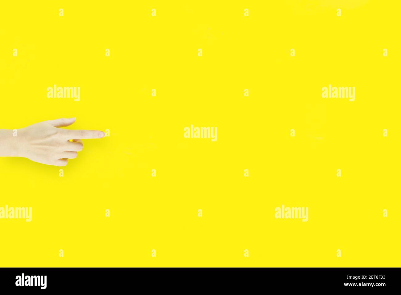 Indice della mano su sfondo giallo, che mostra o punta a qualcosa di invisibile. Foto Stock