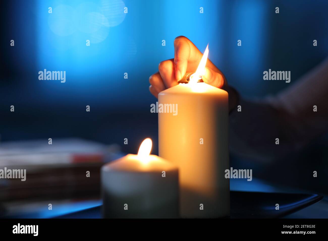 Primo piano di una candela di illuminazione mano donna nel notte a casa Foto Stock