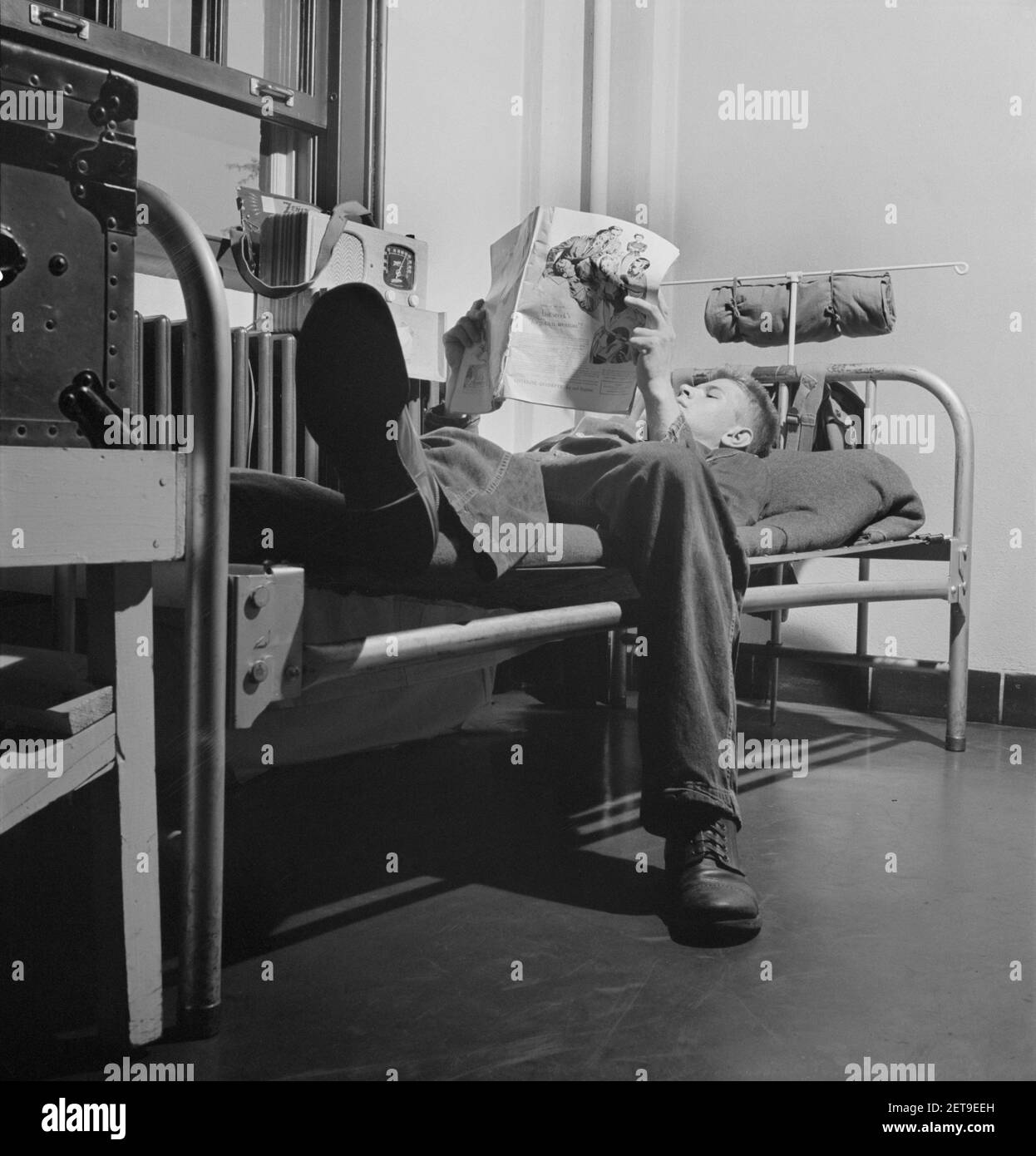 Il sergente George Camblair che legge un articolo in una rivista mentre si rilassa dopo cena, Fort Belvoir, Virginia, USA, Jack Delano, Ufficio delle informazioni di guerra degli Stati Uniti, settembre 1942 Foto Stock