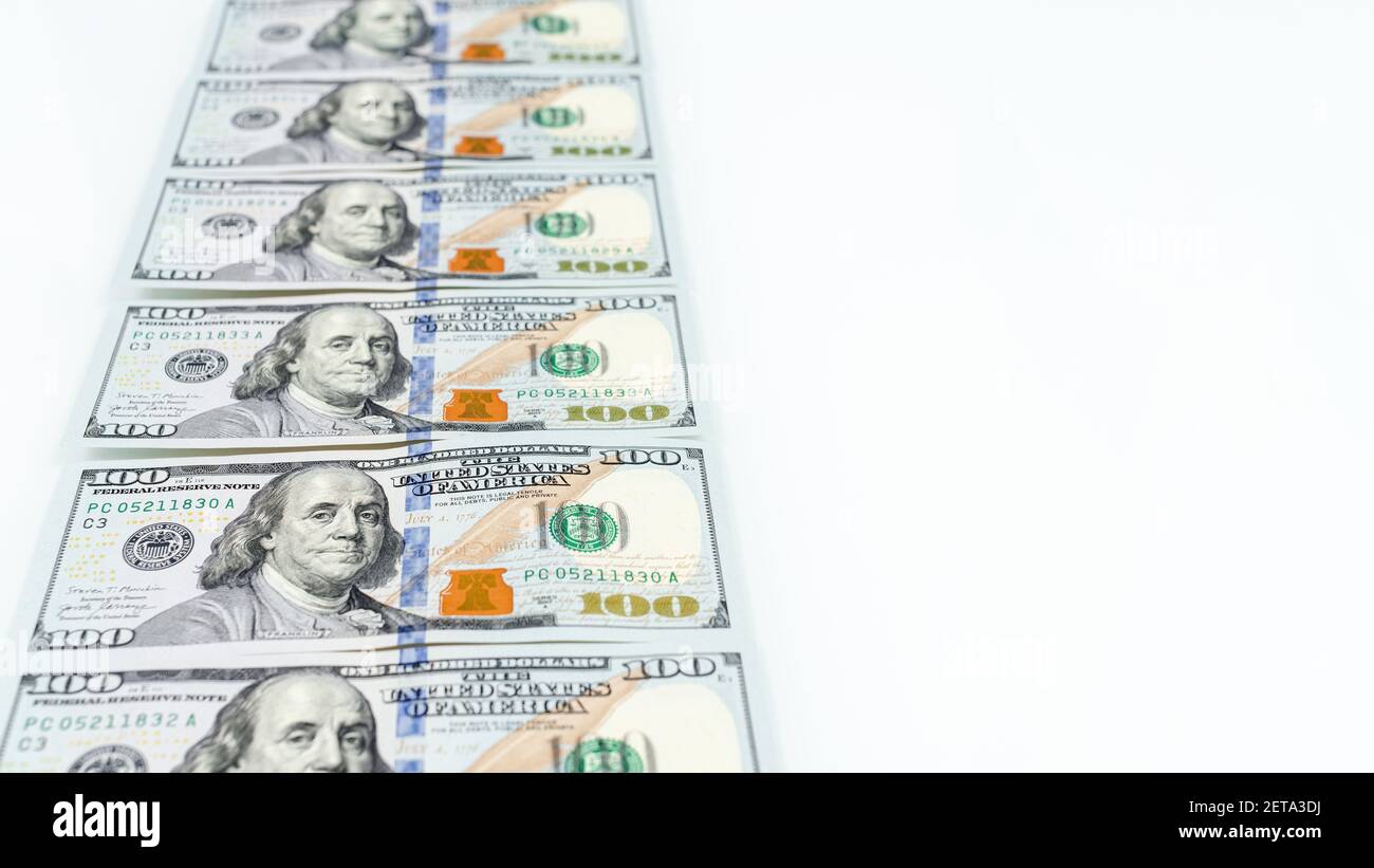 Una serie di banconote da 100 dollari che partono in lontananza. Messa a fuoco selettiva. Serie 2013 di cento dollari USA fatture come concetto ricco. Bianco ba Foto Stock