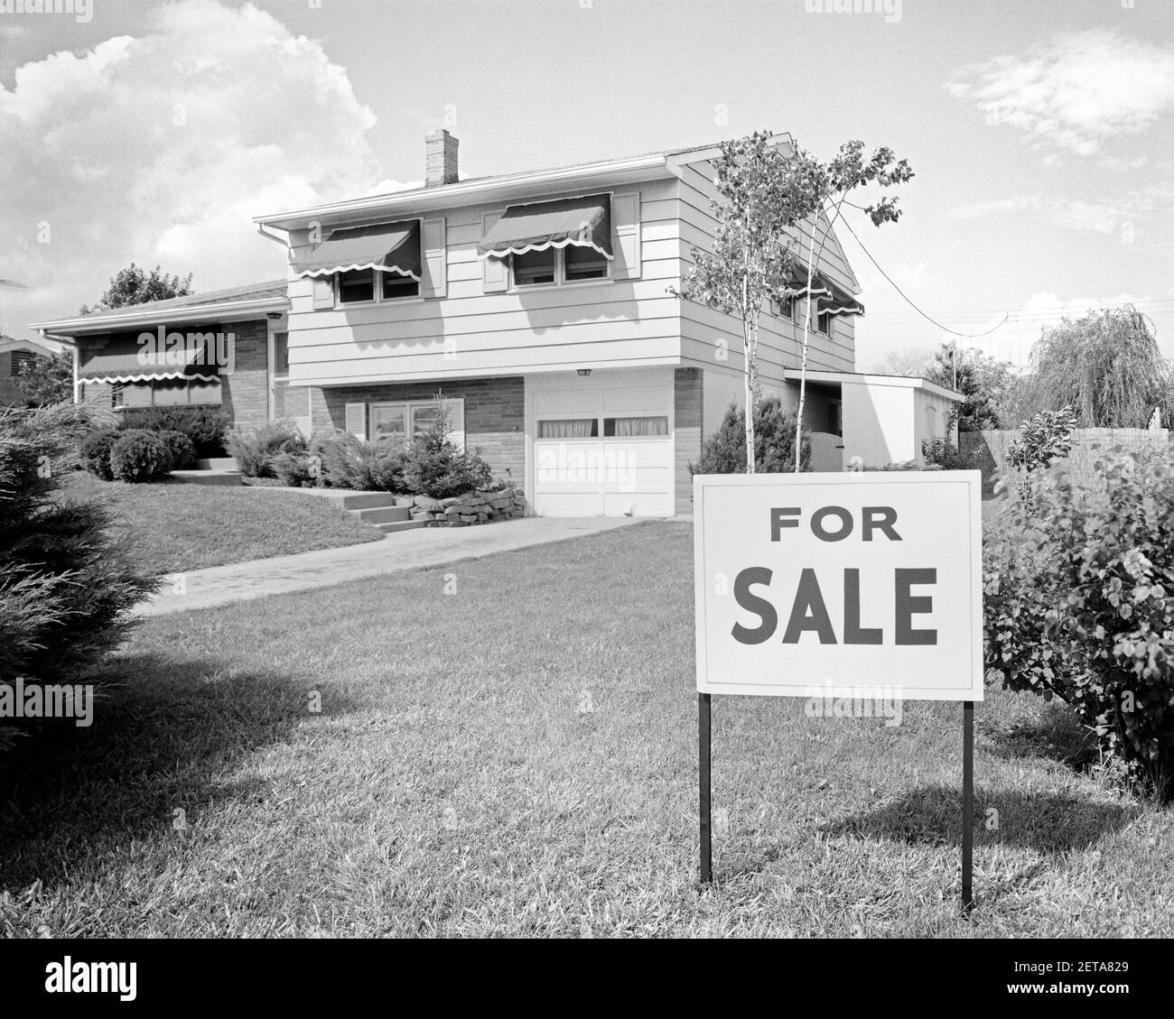 1960 CASA SUBURBANA SU DUE LIVELLI IN VENDITA SEGNO IN PRATO ANTERIORE CON GARAGE SINGOLO E TENDE IN TELA - B22877 HAR001 HARS STRUTTURE RESIDENCE EDIFICIO A LIVELLO DIVISO CONCETTI SIMBOLICI LIVELLO BIANCO E NERO HAR001 RAPPRESENTAZIONE IN VECCHIO STILE Foto Stock