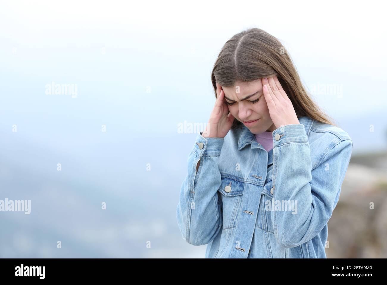 Donna stressata che soffre di emicrania in montagna Foto Stock