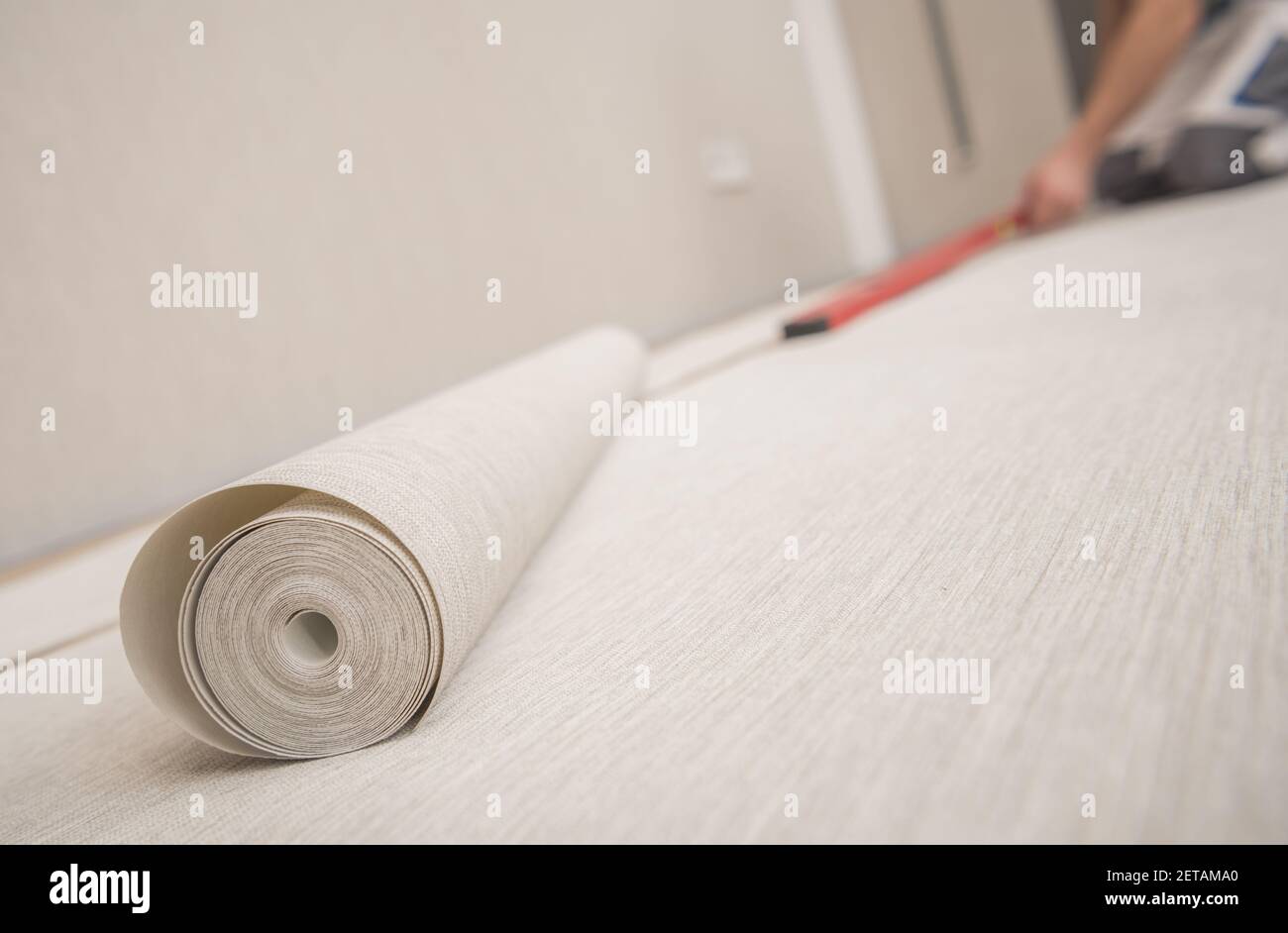 Rotolo di moderna carta da parati in vinile e preparazione dell'applicazione all'interno della Home Room. Foto Stock