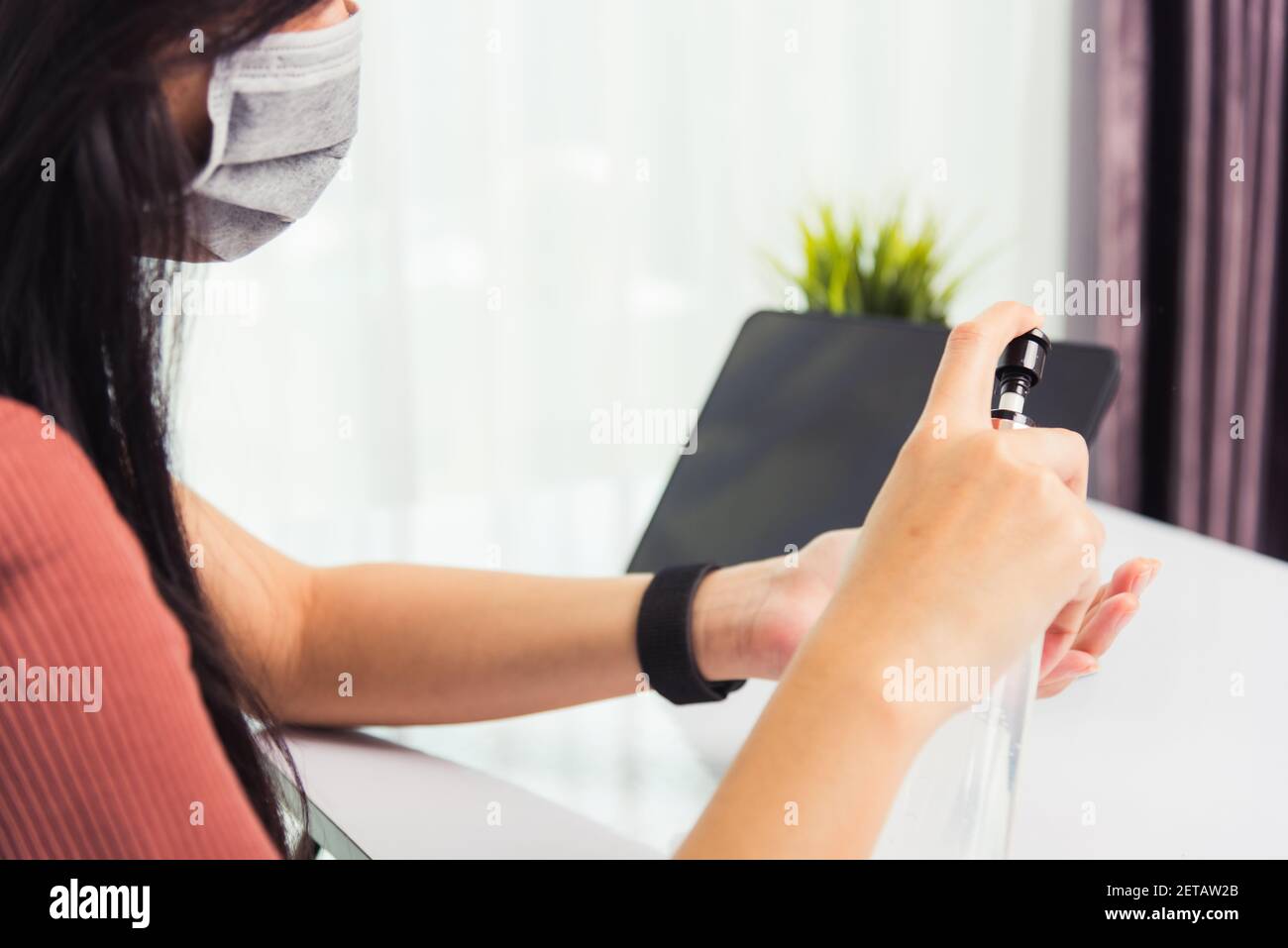 Asian Business giovane donna che lavora da casa ufficio ha quarantine malattia coronavirus o COVID-19 indossare una maschera protettiva e pulizia mani con s. Foto Stock