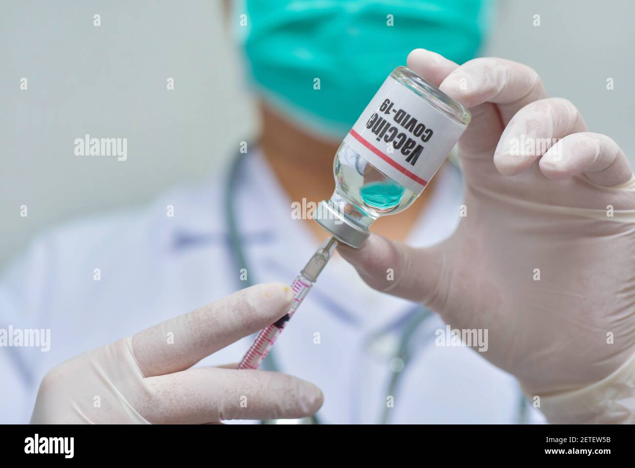 Medico che tiene siringa e Covid-19 vaccino flaconcino-medicina, ricerca farmaceutica e concetto di assistenza sanitaria. Foto Stock
