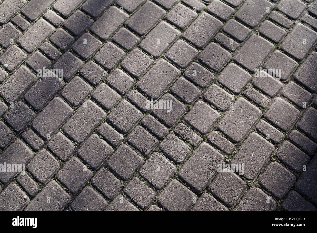 Consistenza di pietre di pavimentazione di pietra. Strada lastricata diagonale sul marciapiede. Superficie dura. Pavimentazione in pietra in prospettiva. Ciottoli di granito. Abst Foto Stock