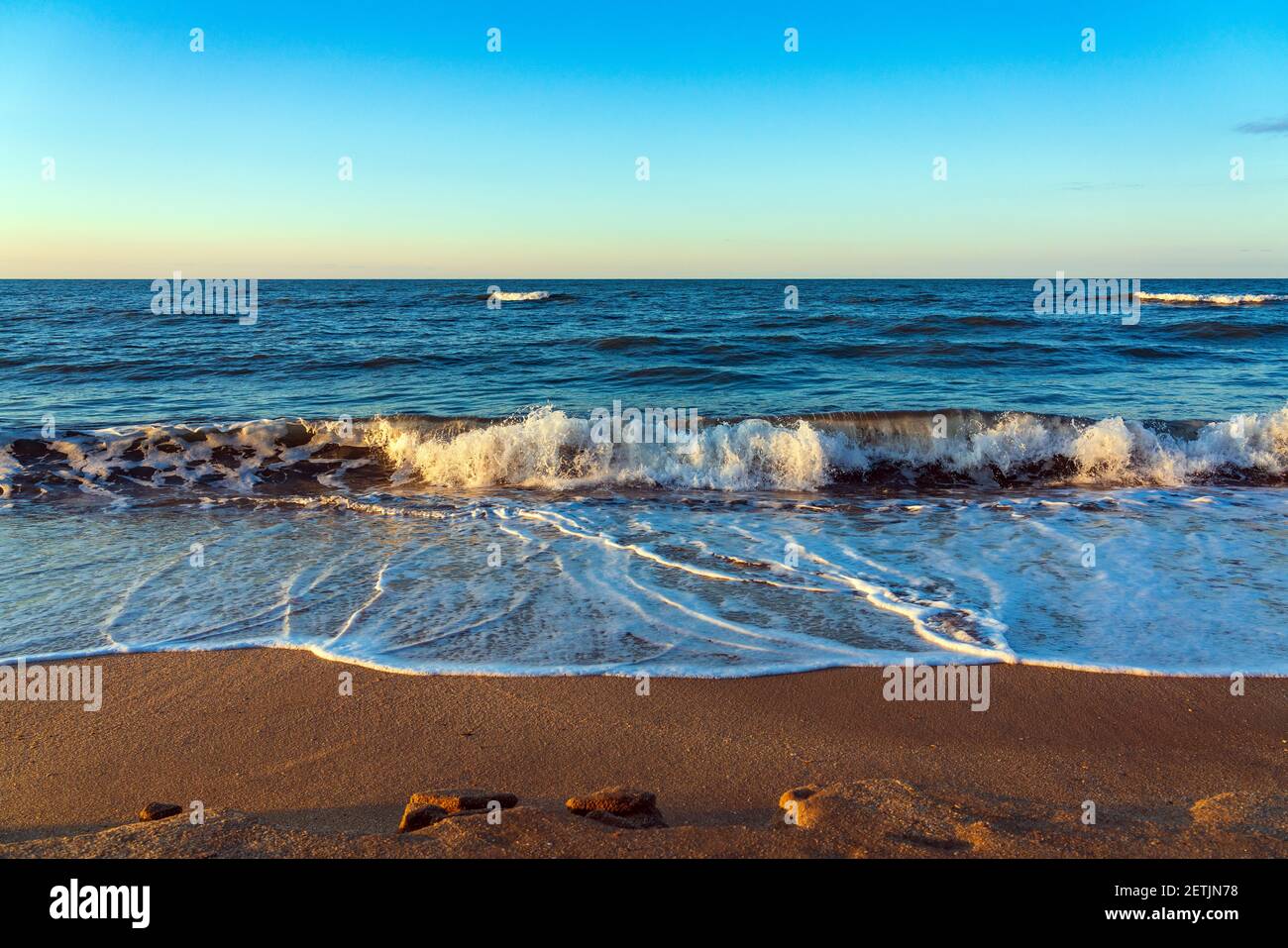 Spiaggia vuota con sabbia gialla e onde blu, quarantena presso il resort Foto Stock